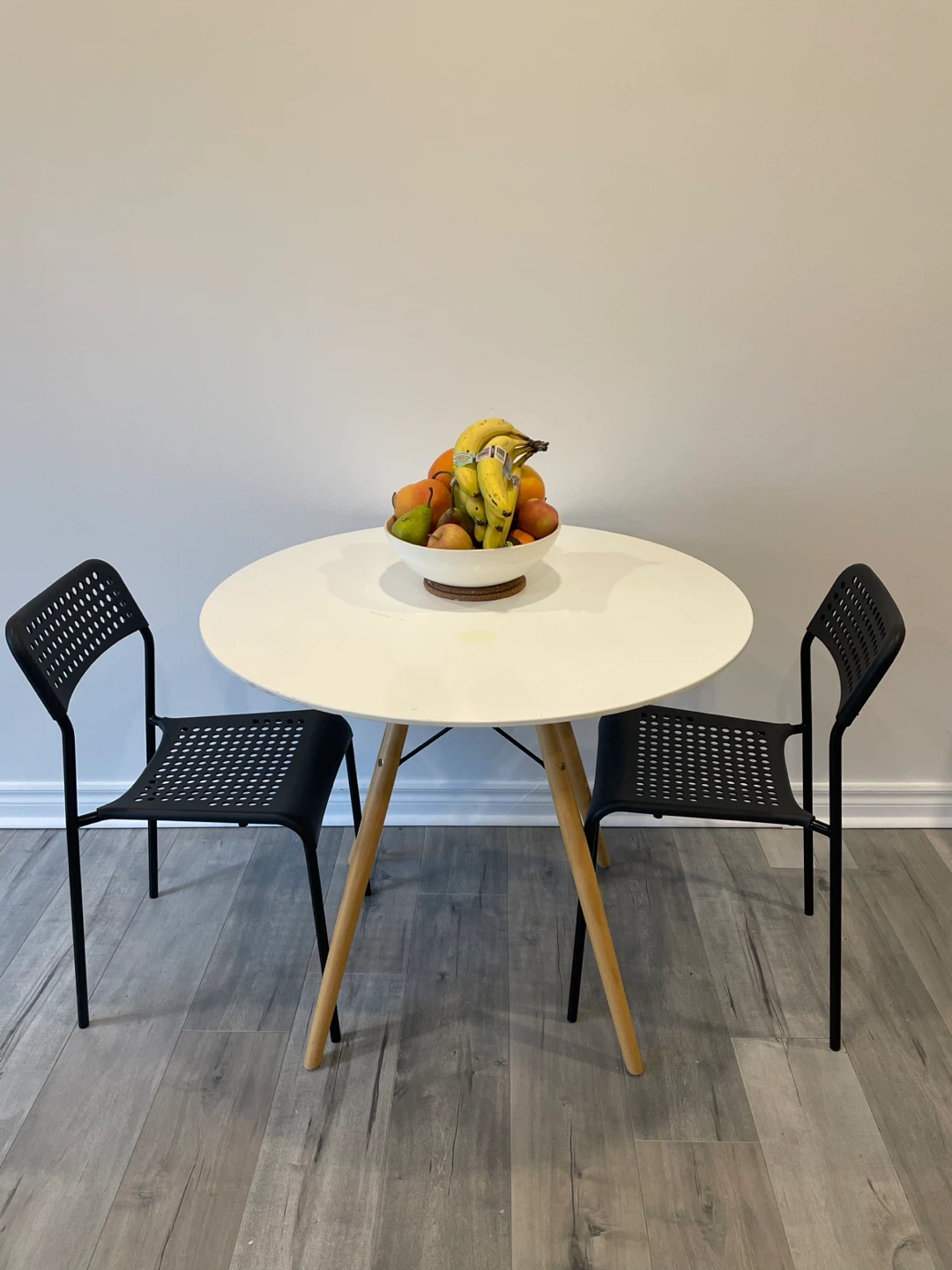 White Round Dining Table with Two Black Chairs