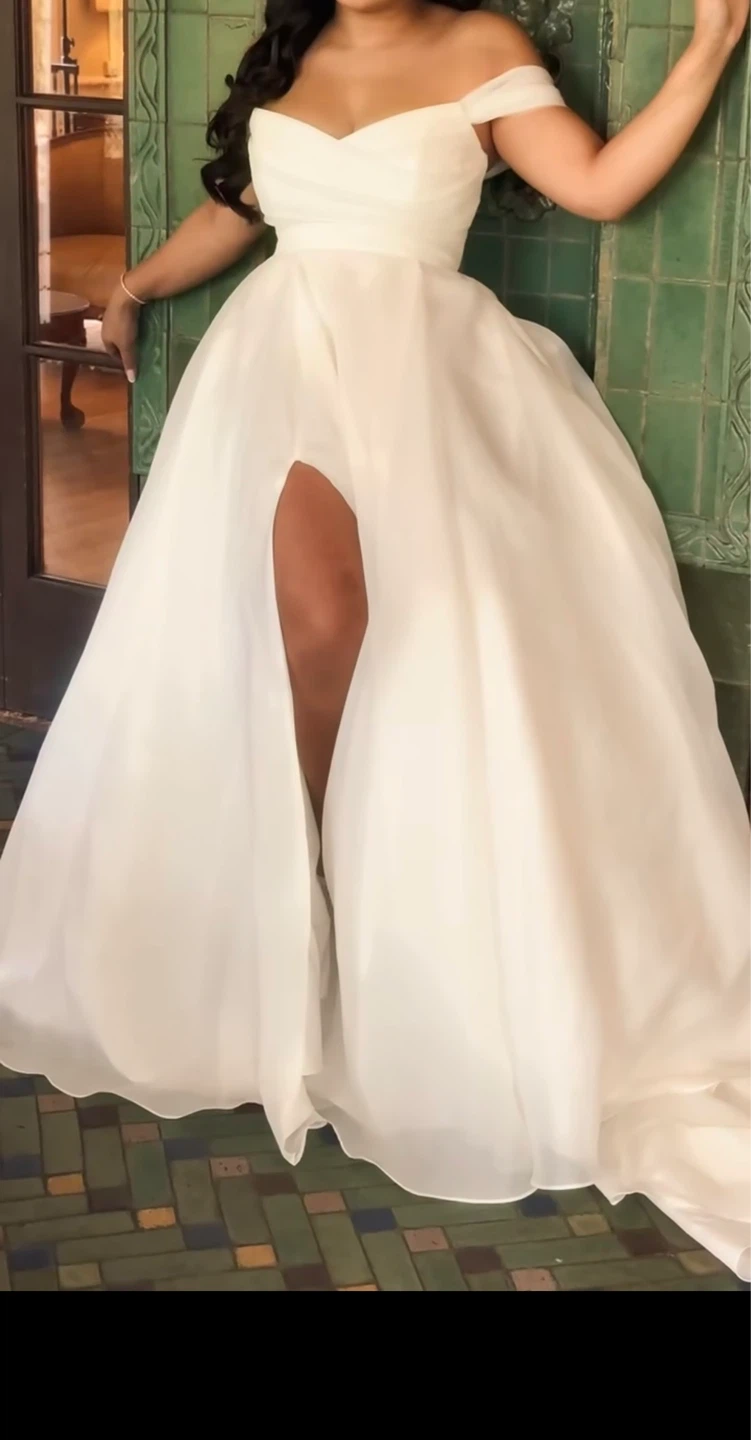 White gown with slit and adjustable straps.