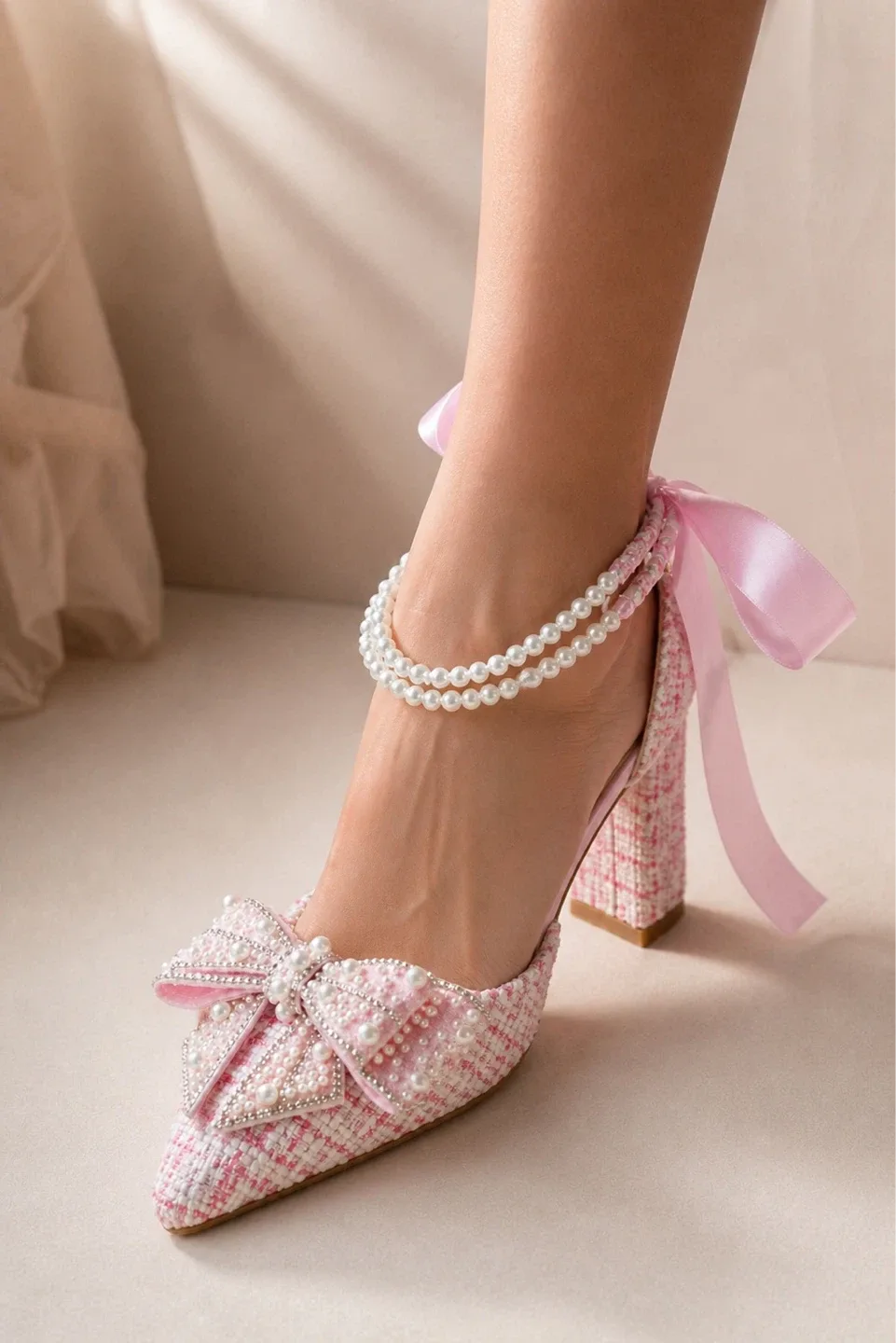 Chaussures roses à talon décorées de perles et d'un nœud