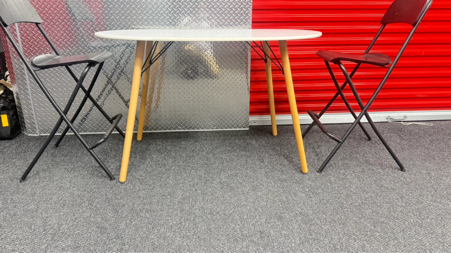 White Oval Dining Table with 2 Black Folding Chairs