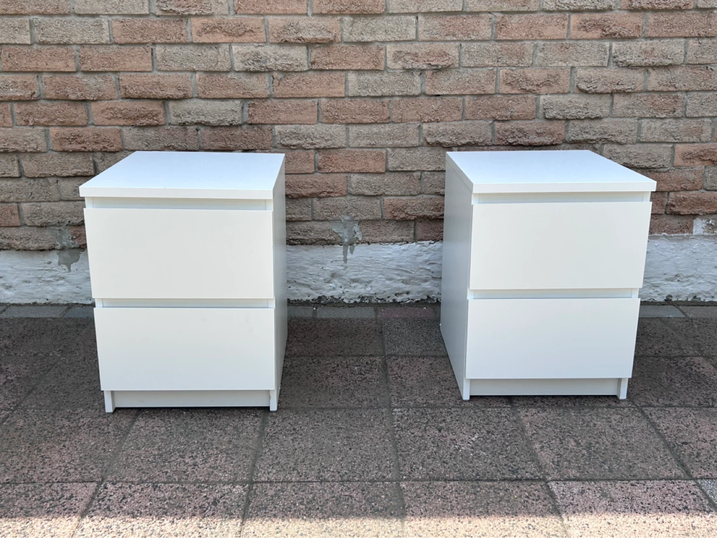Two white bedside tables with drawers