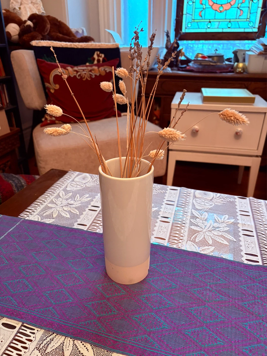 Dried floral arrangement in a white ceramic vase
