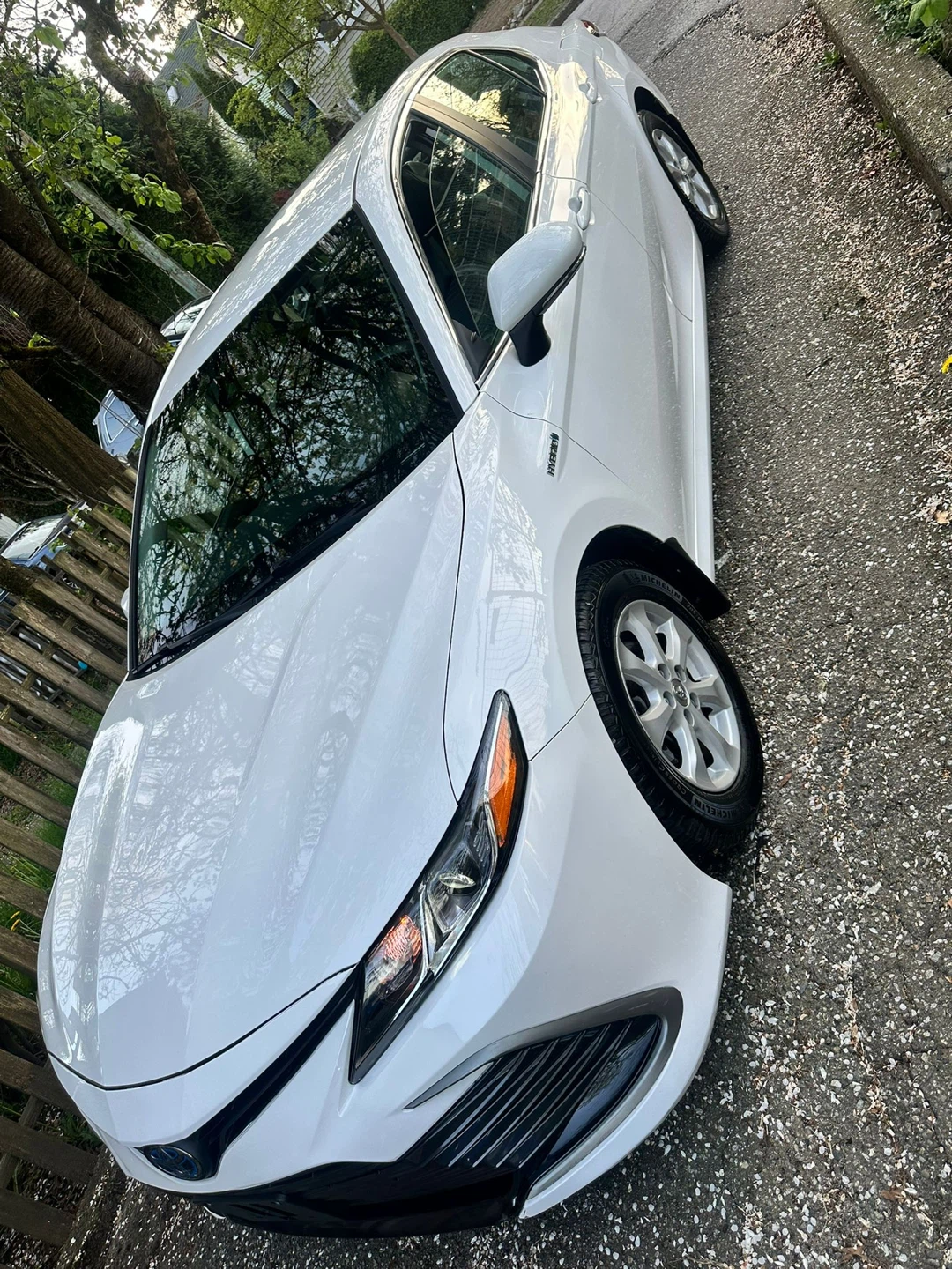 White Toyota Camry LE Hybrid Sedan