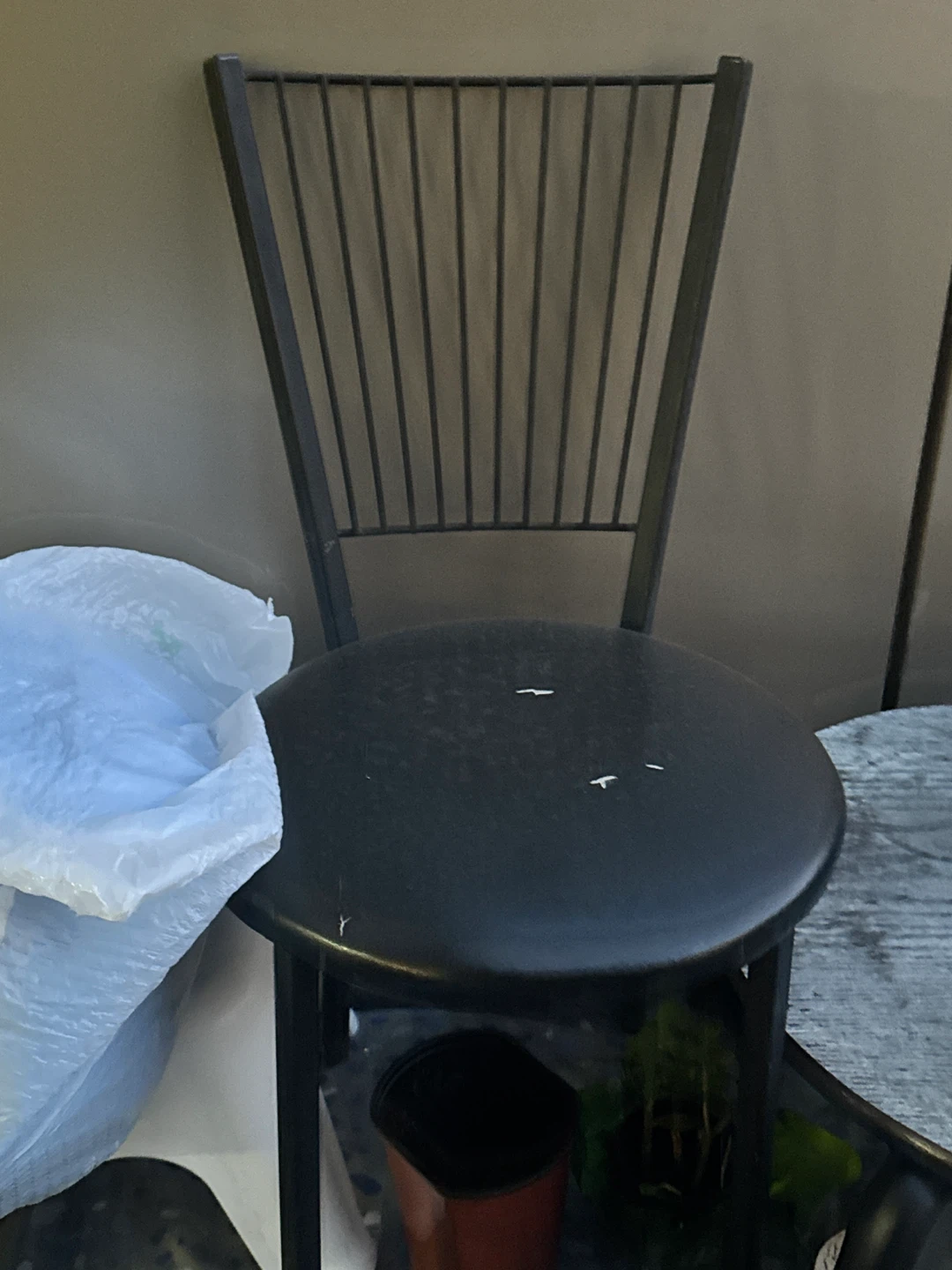 Black metal stool with slatted back