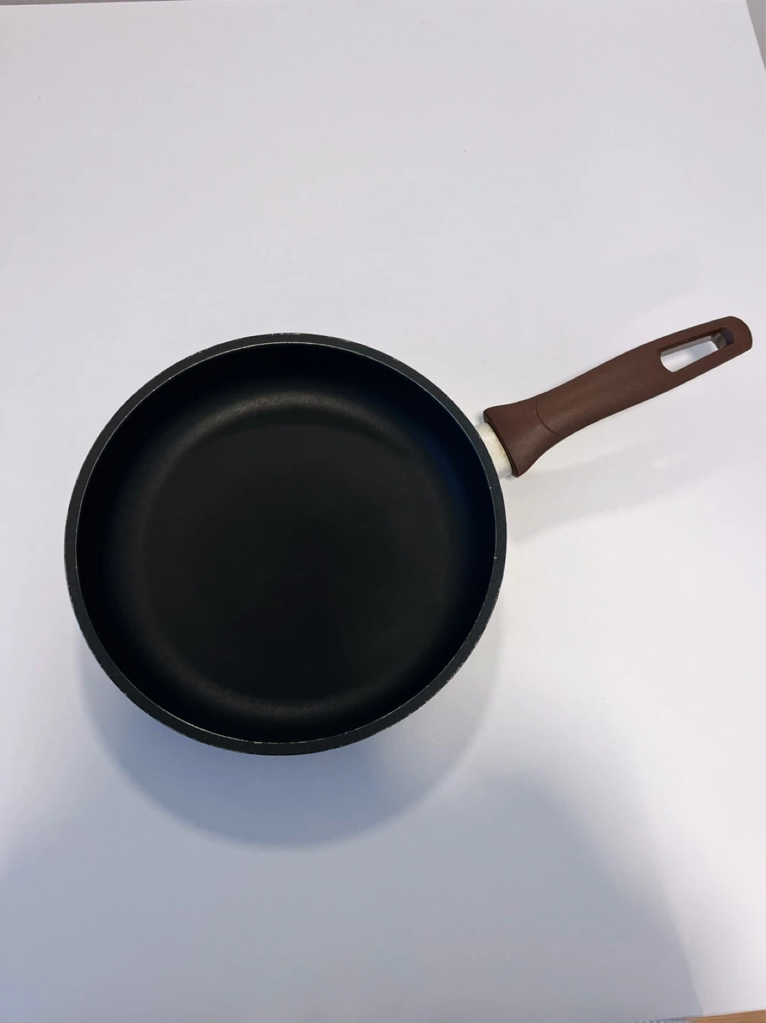 Black frying pan with brown handle