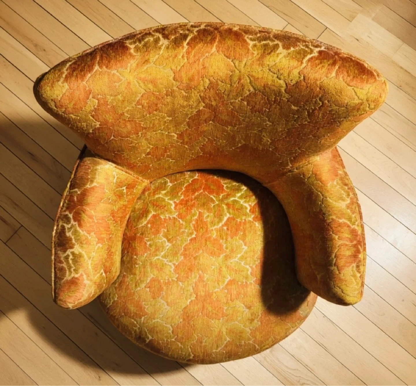 Fauteuil vintage à motifs feuillus orange et jaune