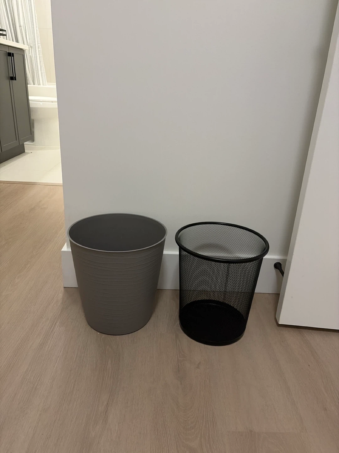 Two Trash Cans: Grey Plastic and Black Mesh