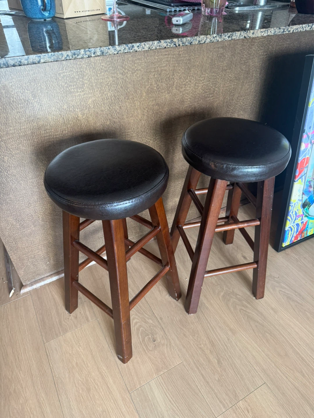 Two dark brown bar stools with wood legs