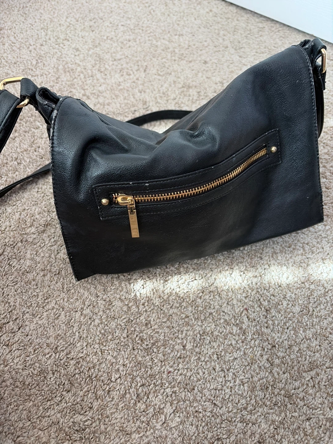 Black faux leather crossbody bag with gold zipper detail