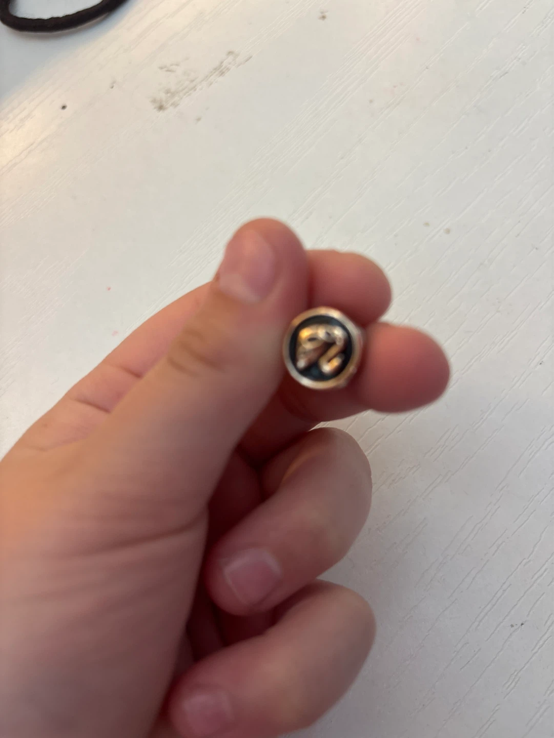 Round Gold Button with Black Detail and '2' Logo