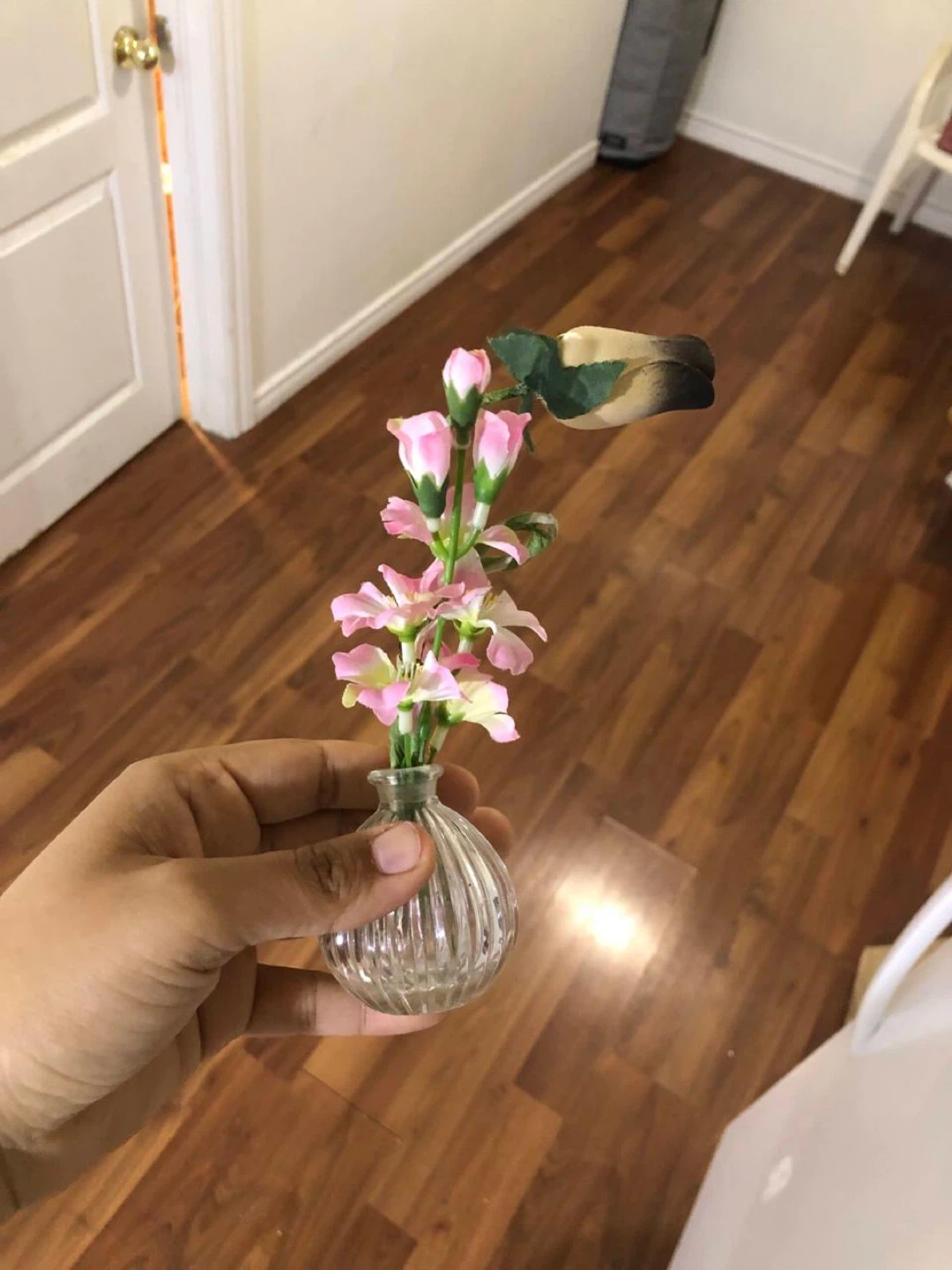 Small glass vase with pink artificial flowers