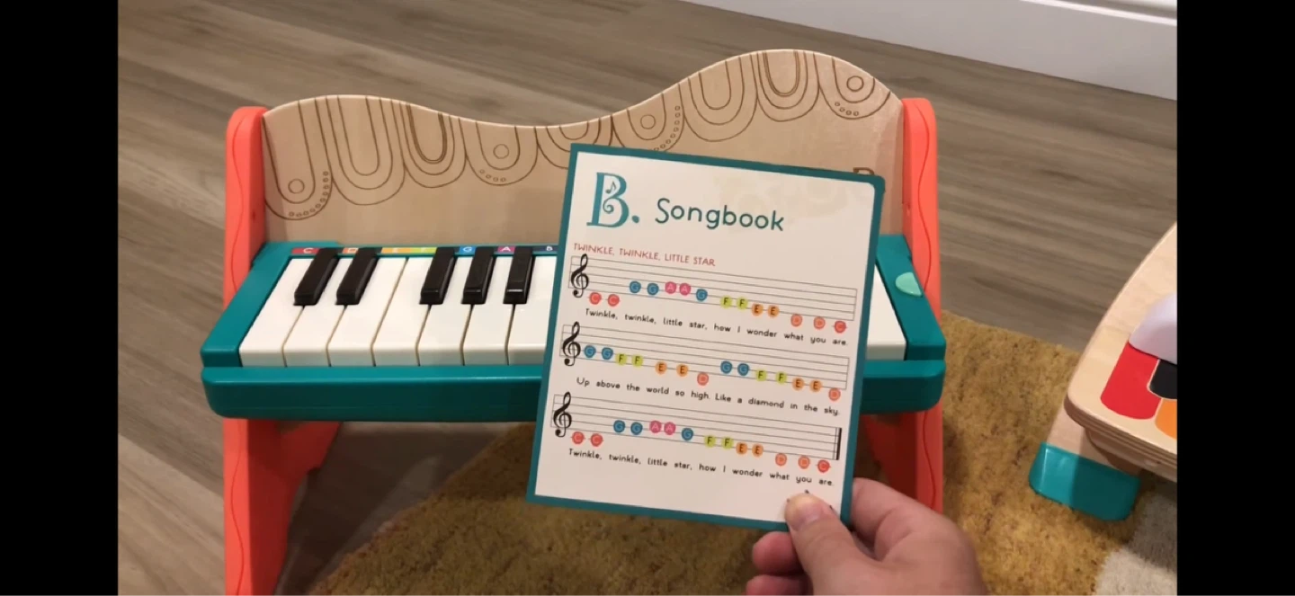 Wooden toy piano with songbook