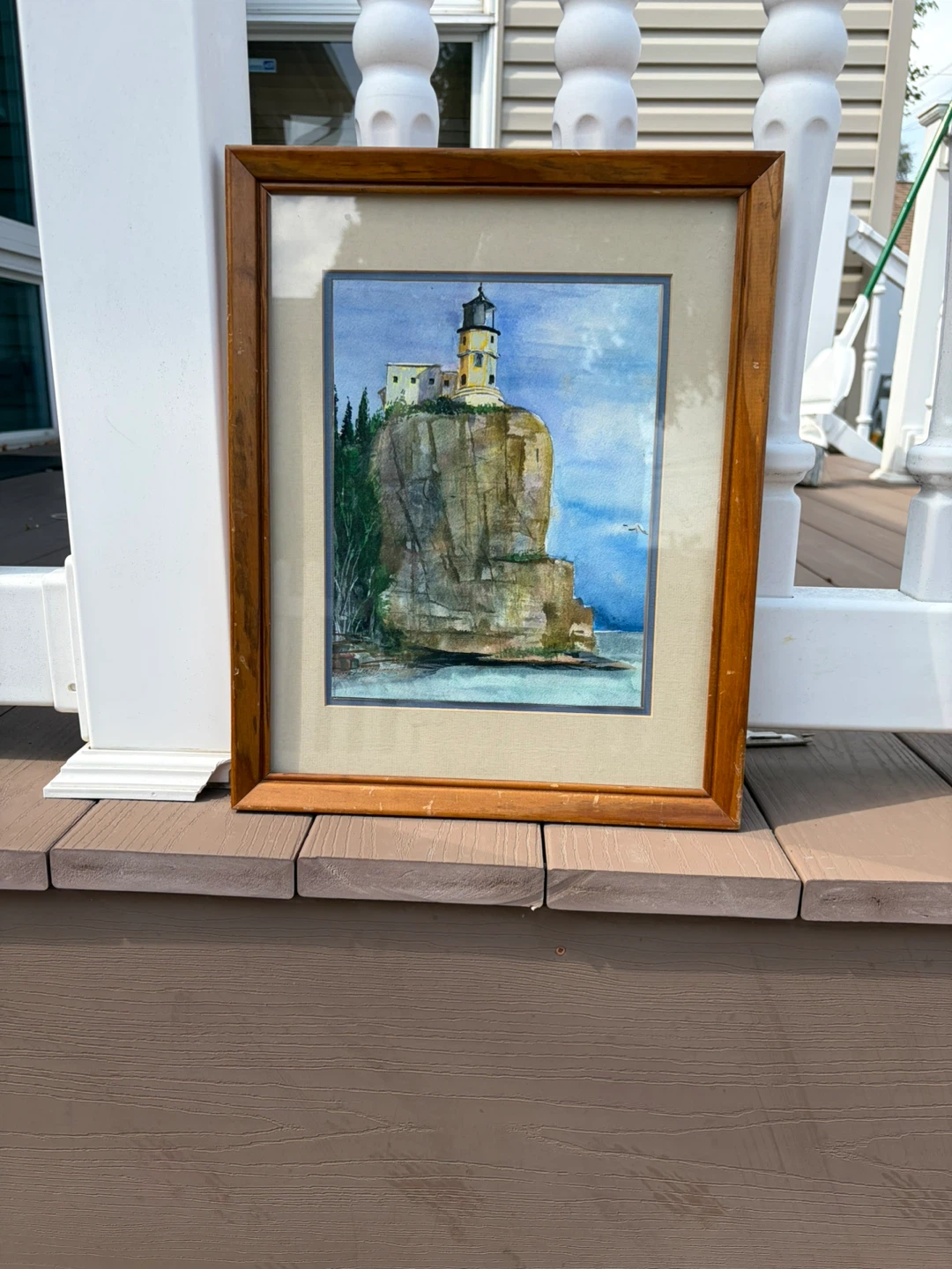 Watercolor painting of a lighthouse on a cliff