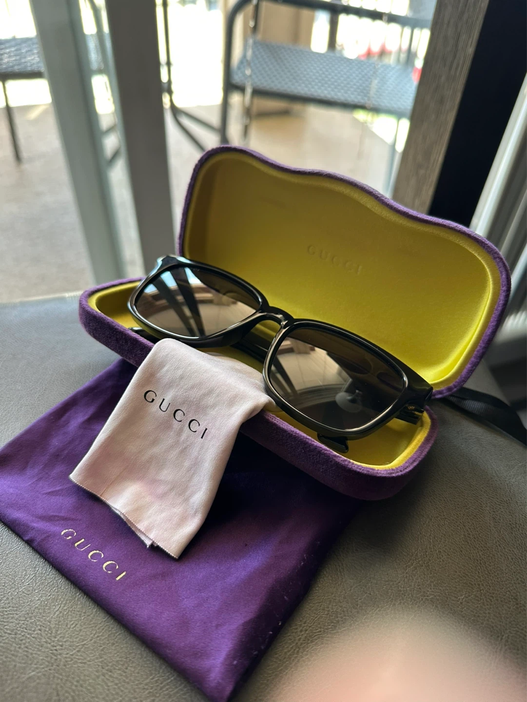 Black Gucci sunglasses with gold GG logo detail. Made in Italy.