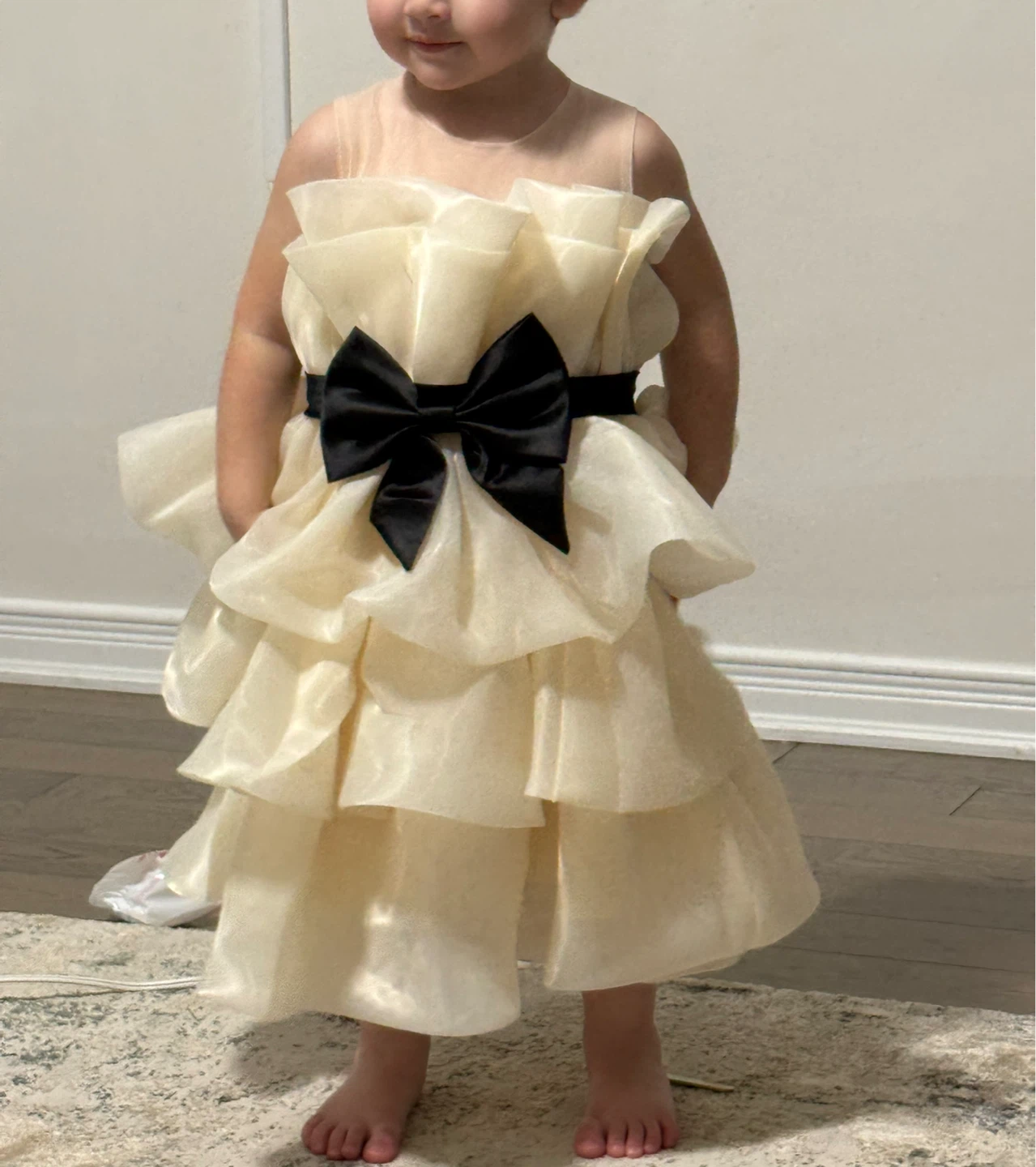 Cream ruffled party dress with black bow