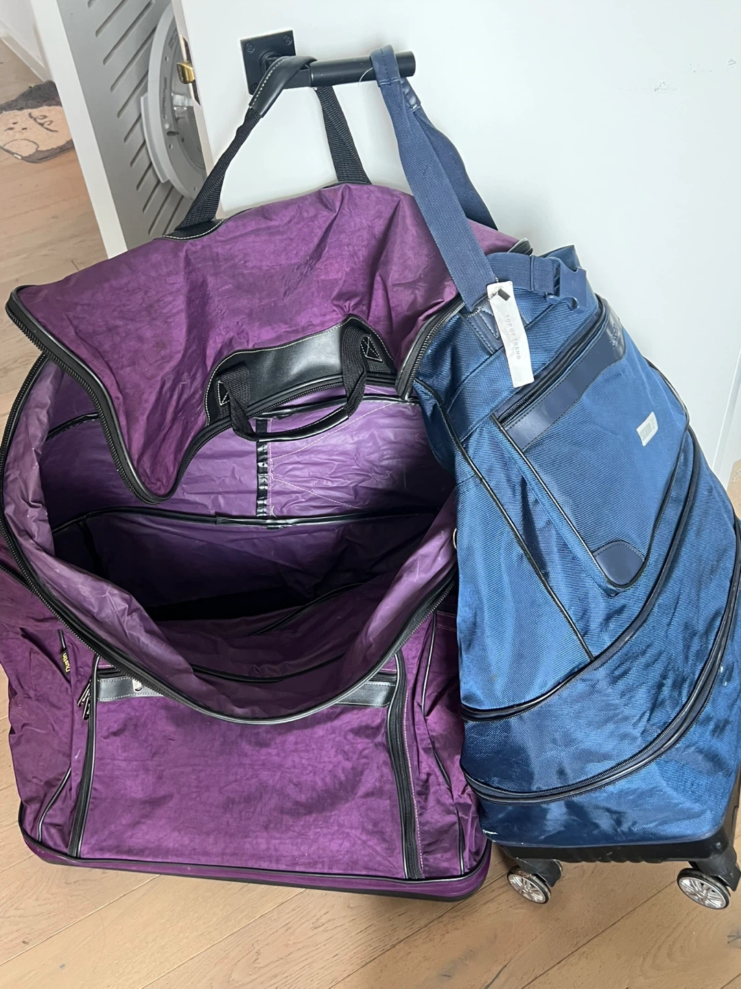 Large Purple Rolling Duffle Bag and Blue Carry-On Suitcase