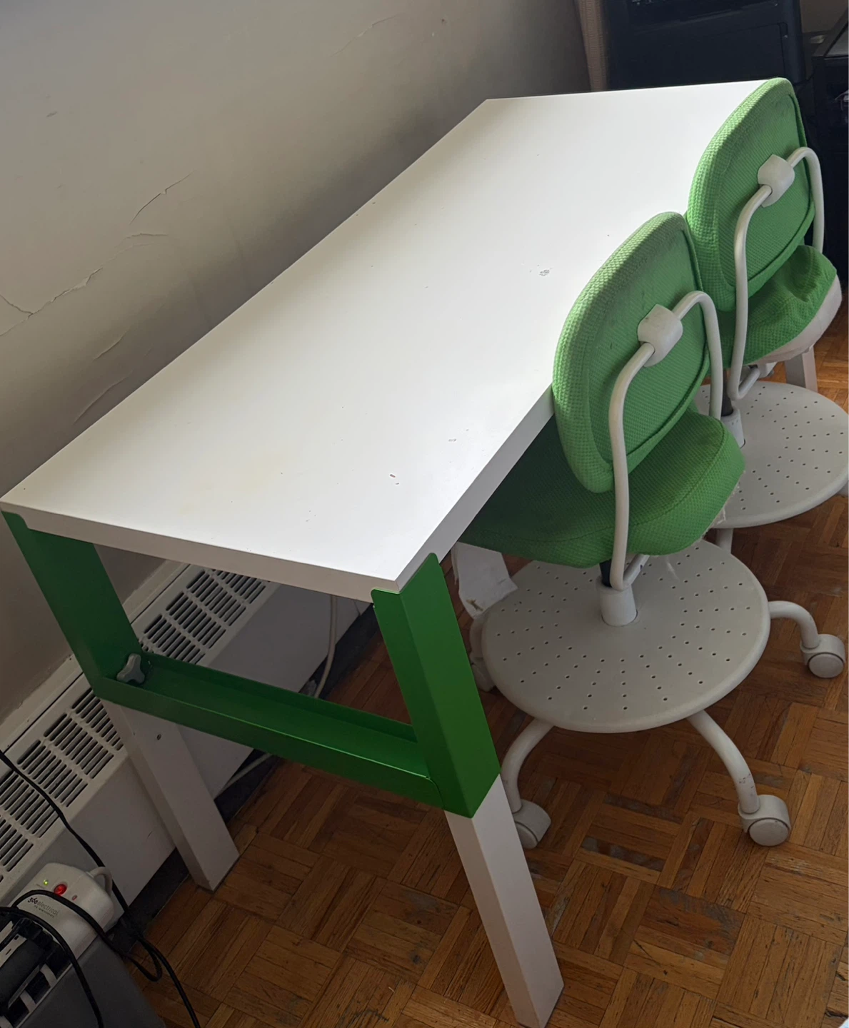 White desk with green trim and two green chairs
