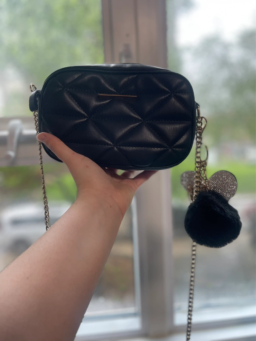Black quilted crossbody bag with charms