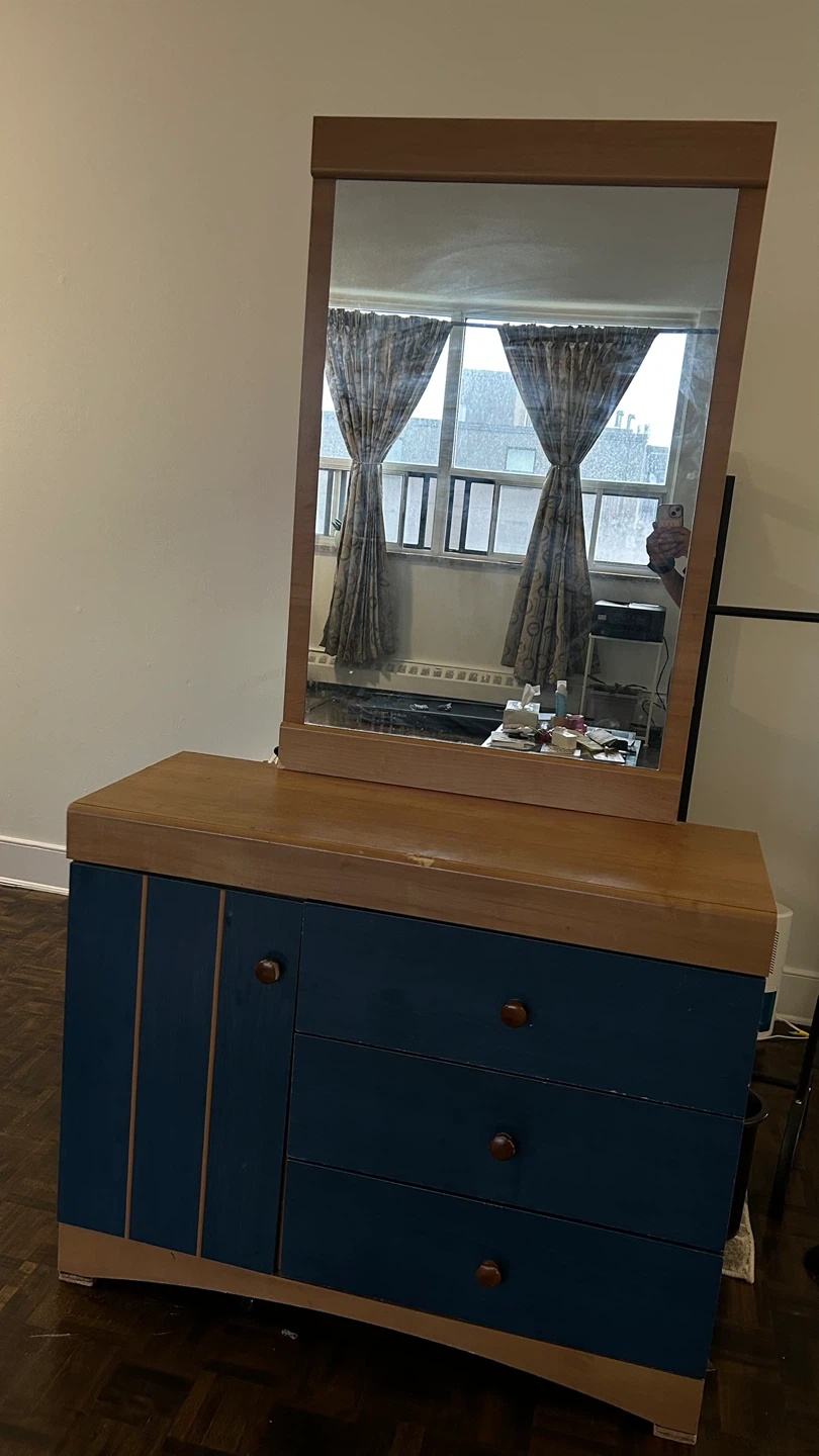 Wooden dresser with navy blue drawers and cabinet