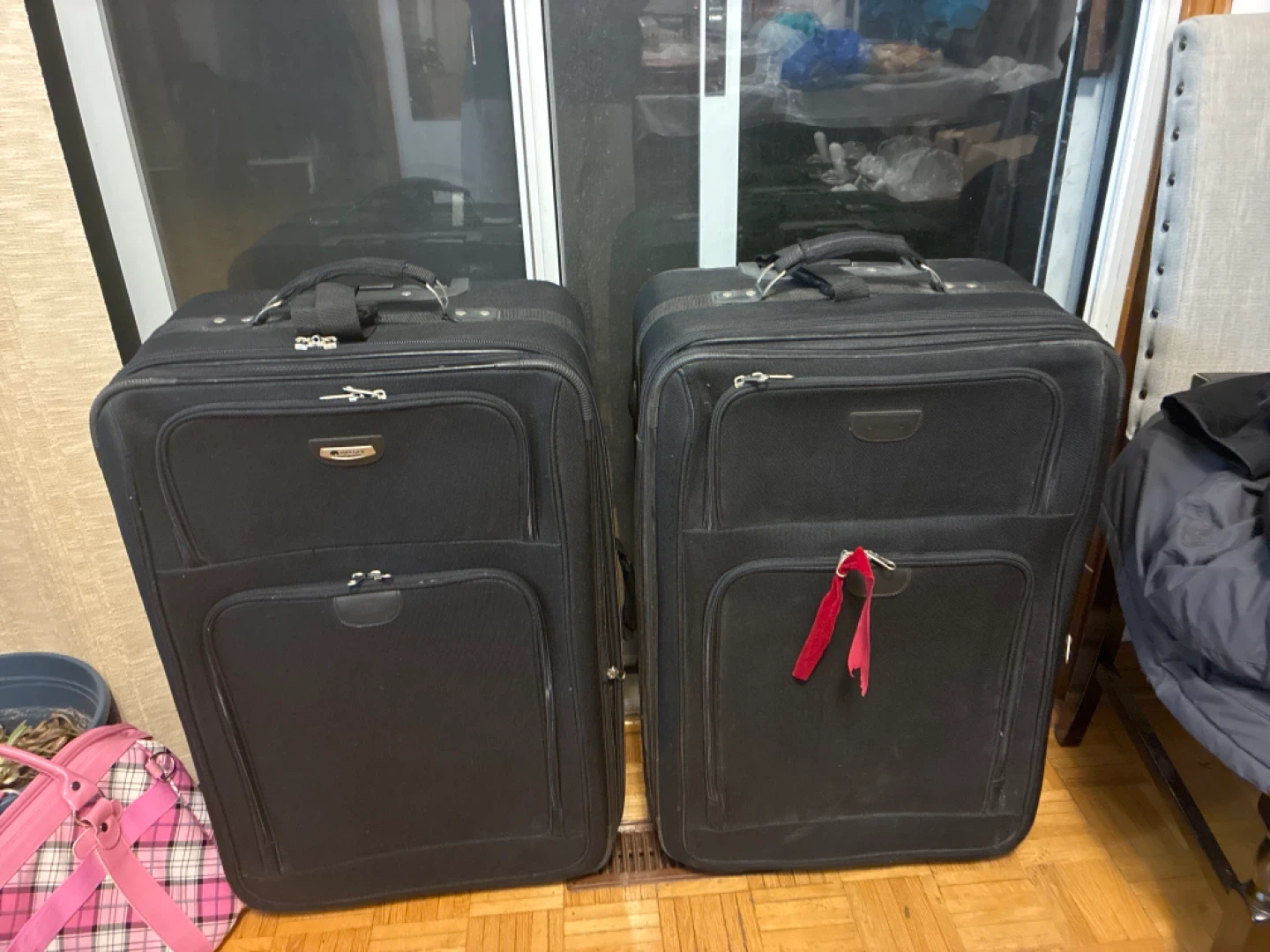 Two Black Delsey Rolling Suitcases