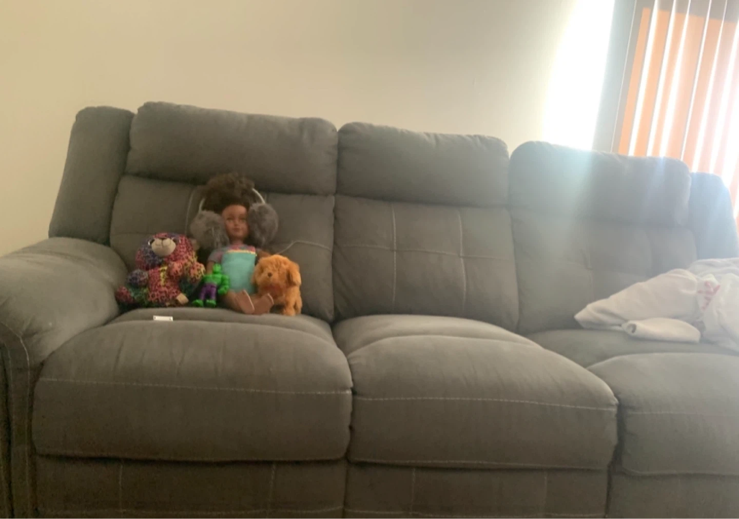 Grey reclining sofa with decorative pillows