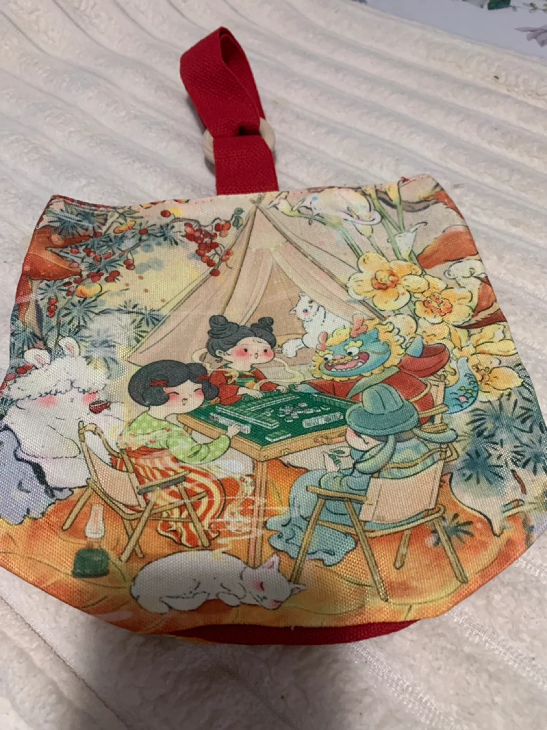 Fabric pouch with mahjong scene and red loop