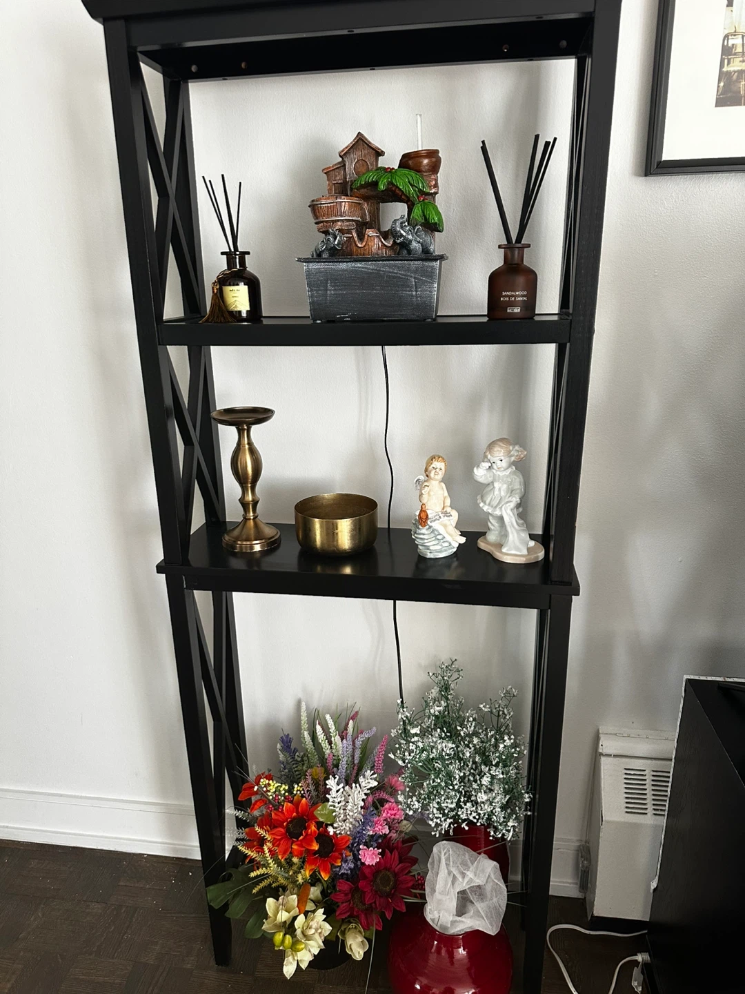 Black leaning bookshelf with decorative items - photo 2