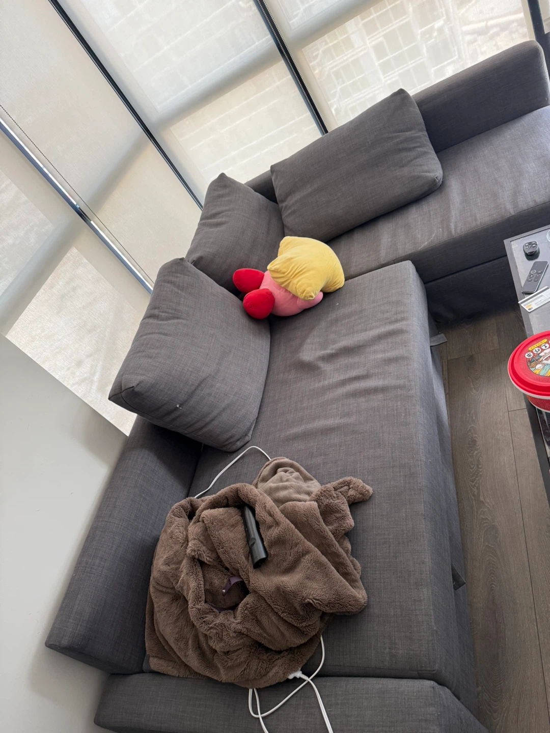 Grey Sectional Sofa with Throw Blanket and Kirby Plush Toy