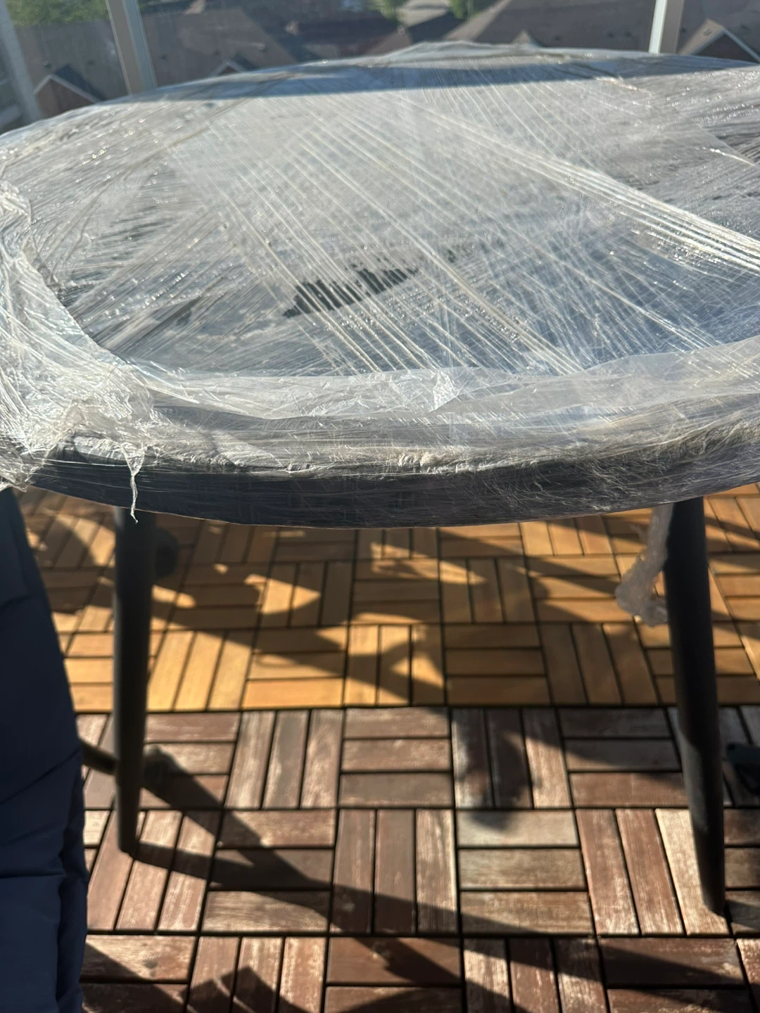 Round patio table with plastic wrap