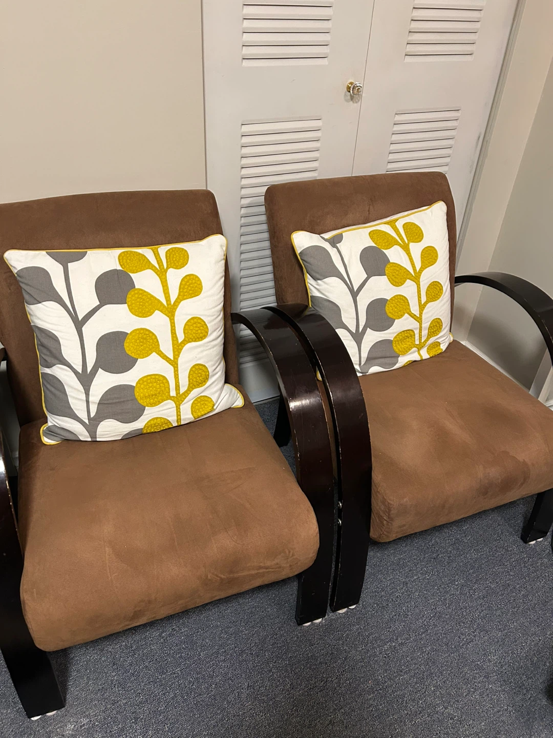 Pair of brown accent chairs with decorative pillows
