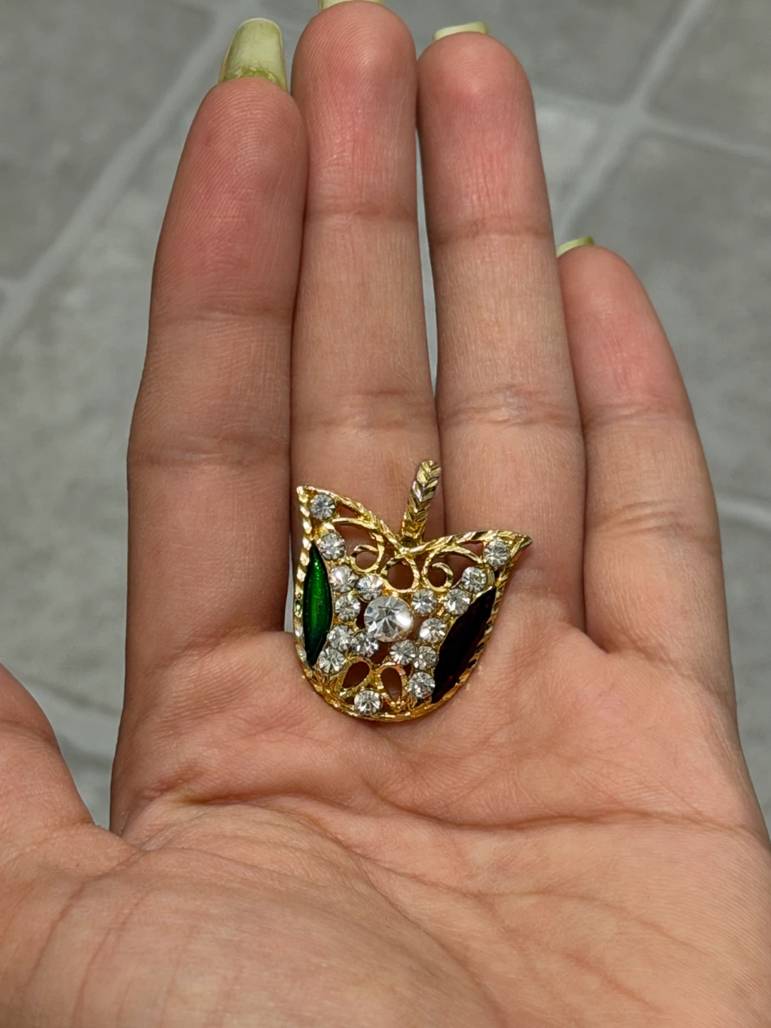 Gold tone pendant with clear and green stones