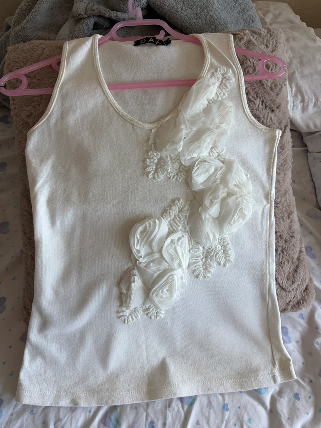 White sleeveless top with floral appliqué