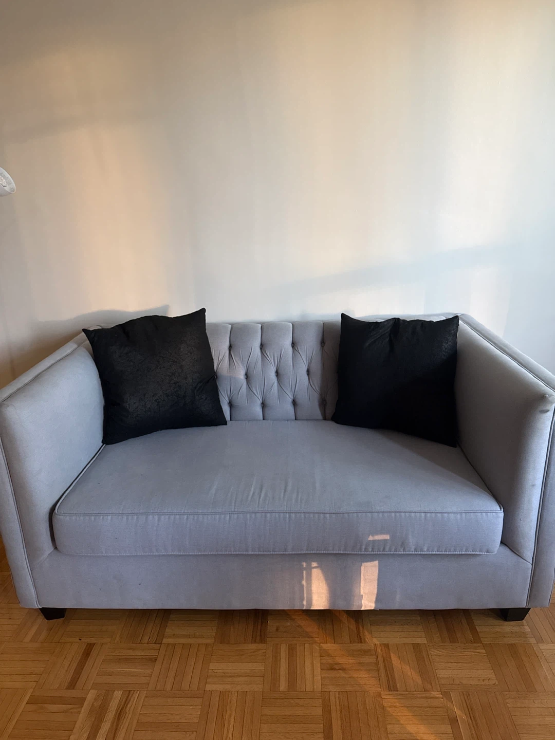 Light Grey Tufted Sofa with Black Pillows