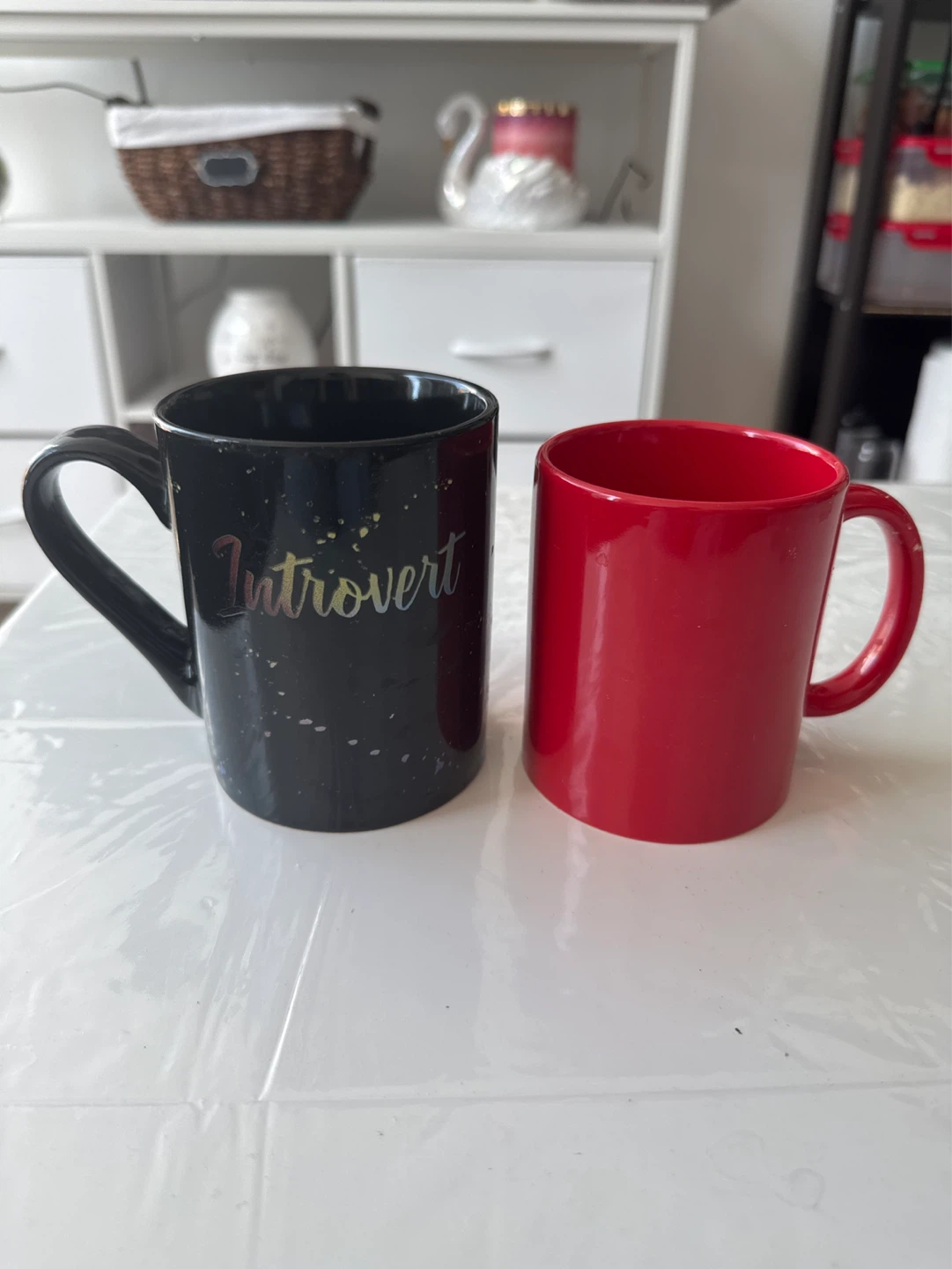 Two Mugs: Black 'Introvert' and Red