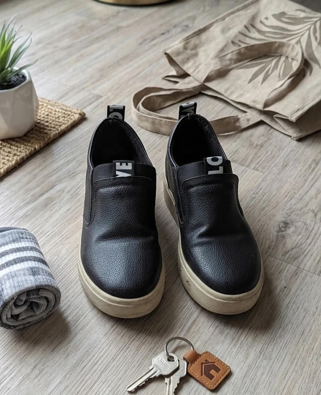 Black slip-on sneakers with 'LOVE' accent