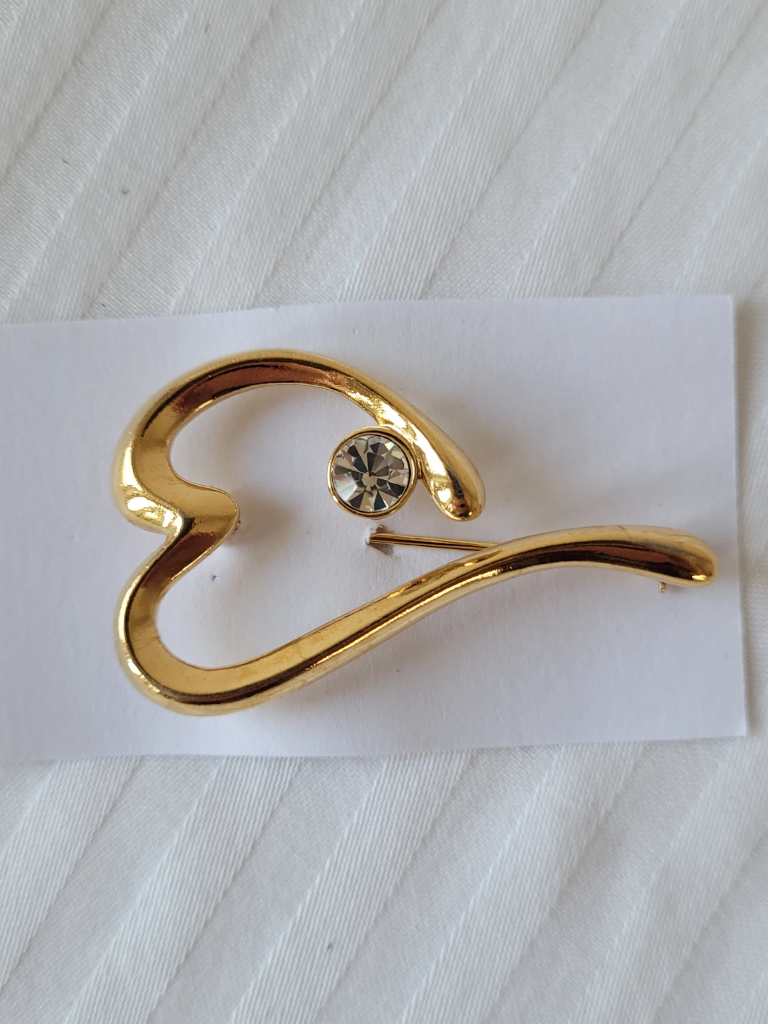Gold tone heart brooch with crystal accent