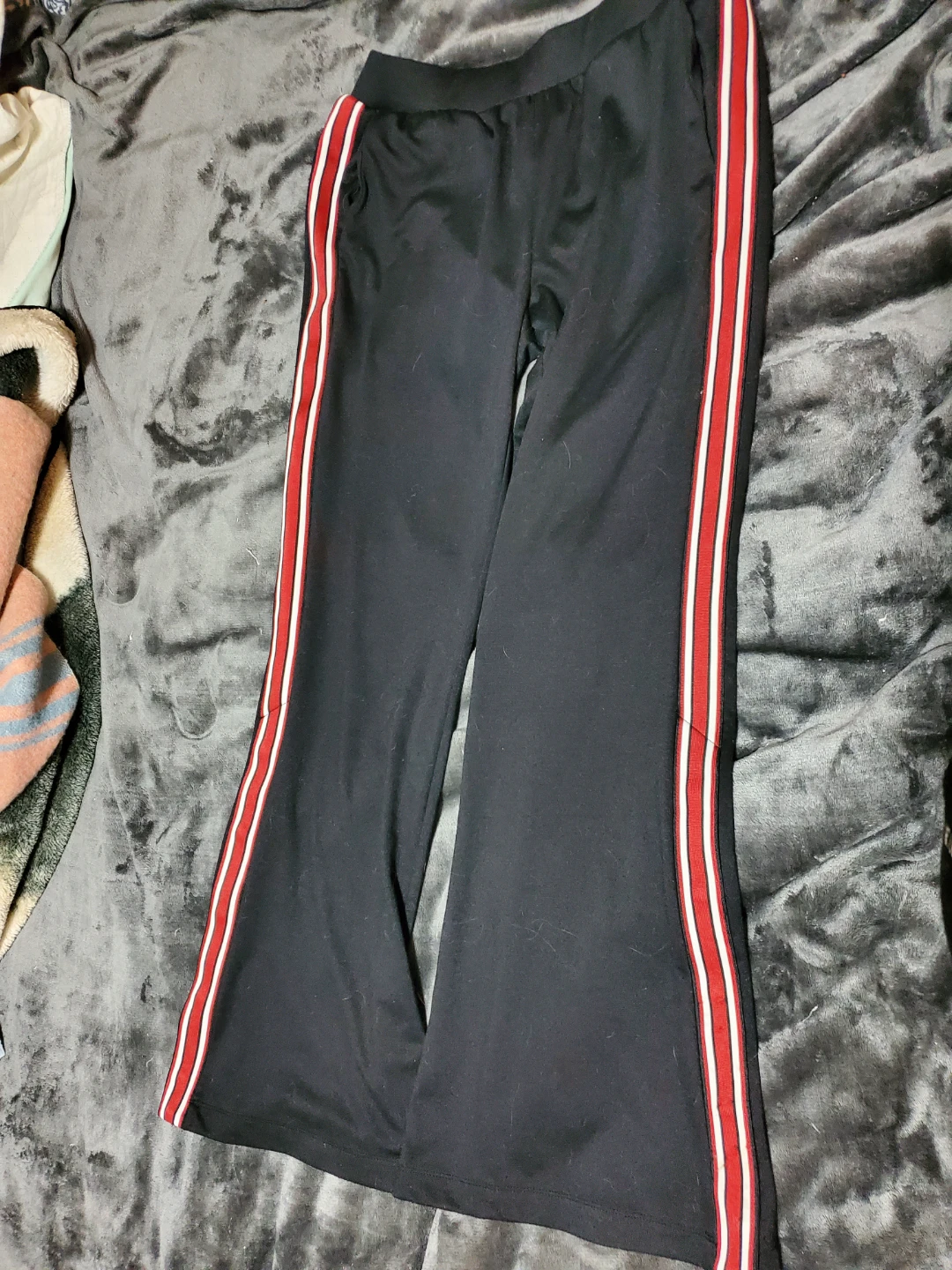 Black flared track pants with red and white stripes