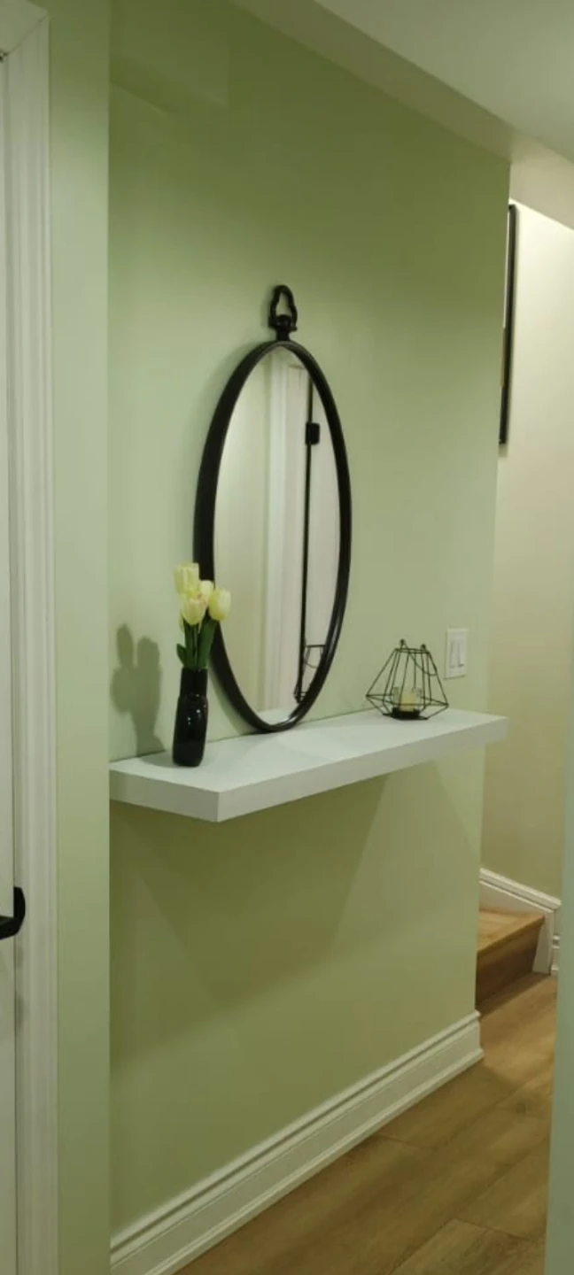 Oval wall mirror with decorative loop