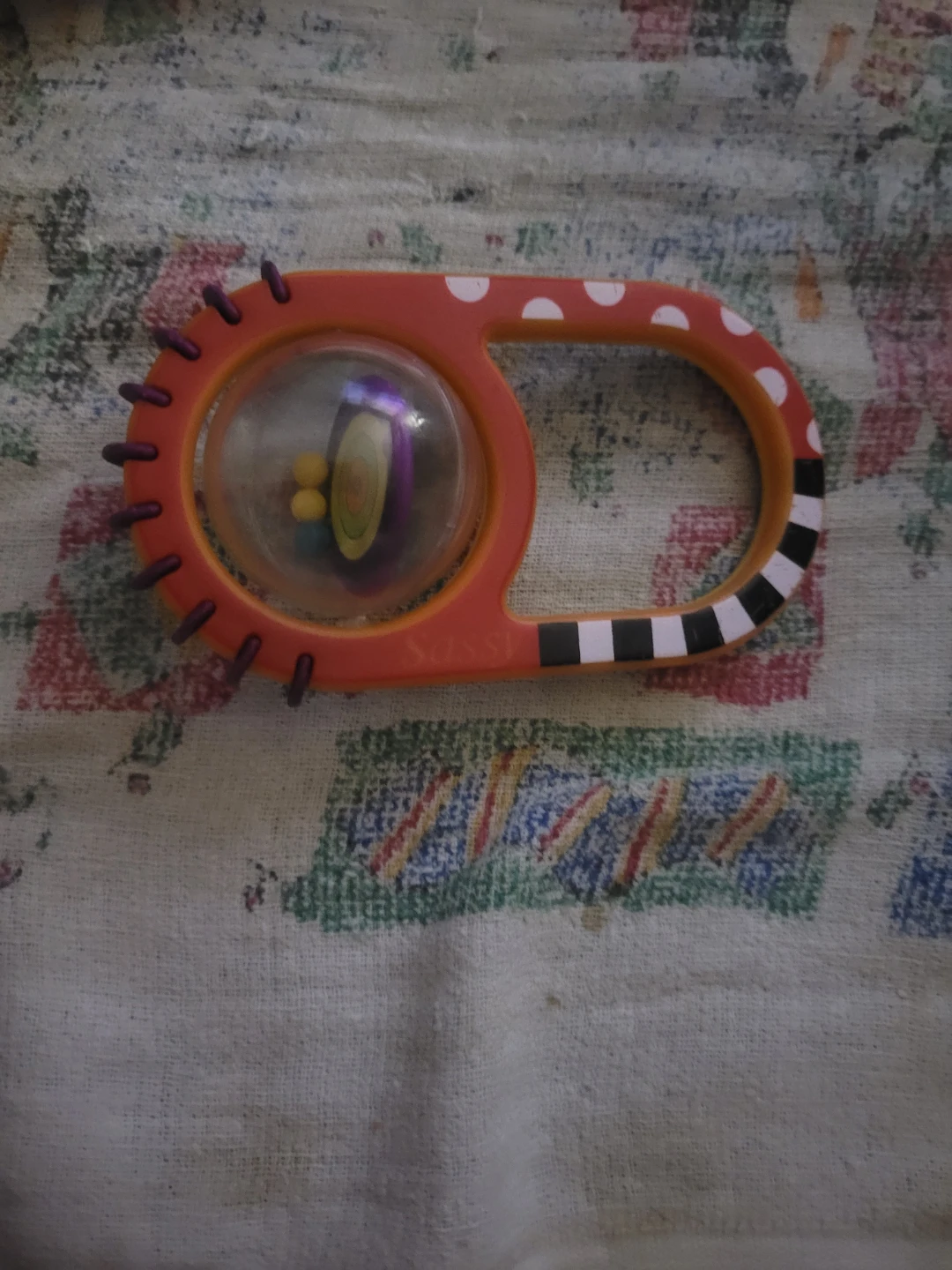 red and black Sassy Baby Rattle sensory toy.