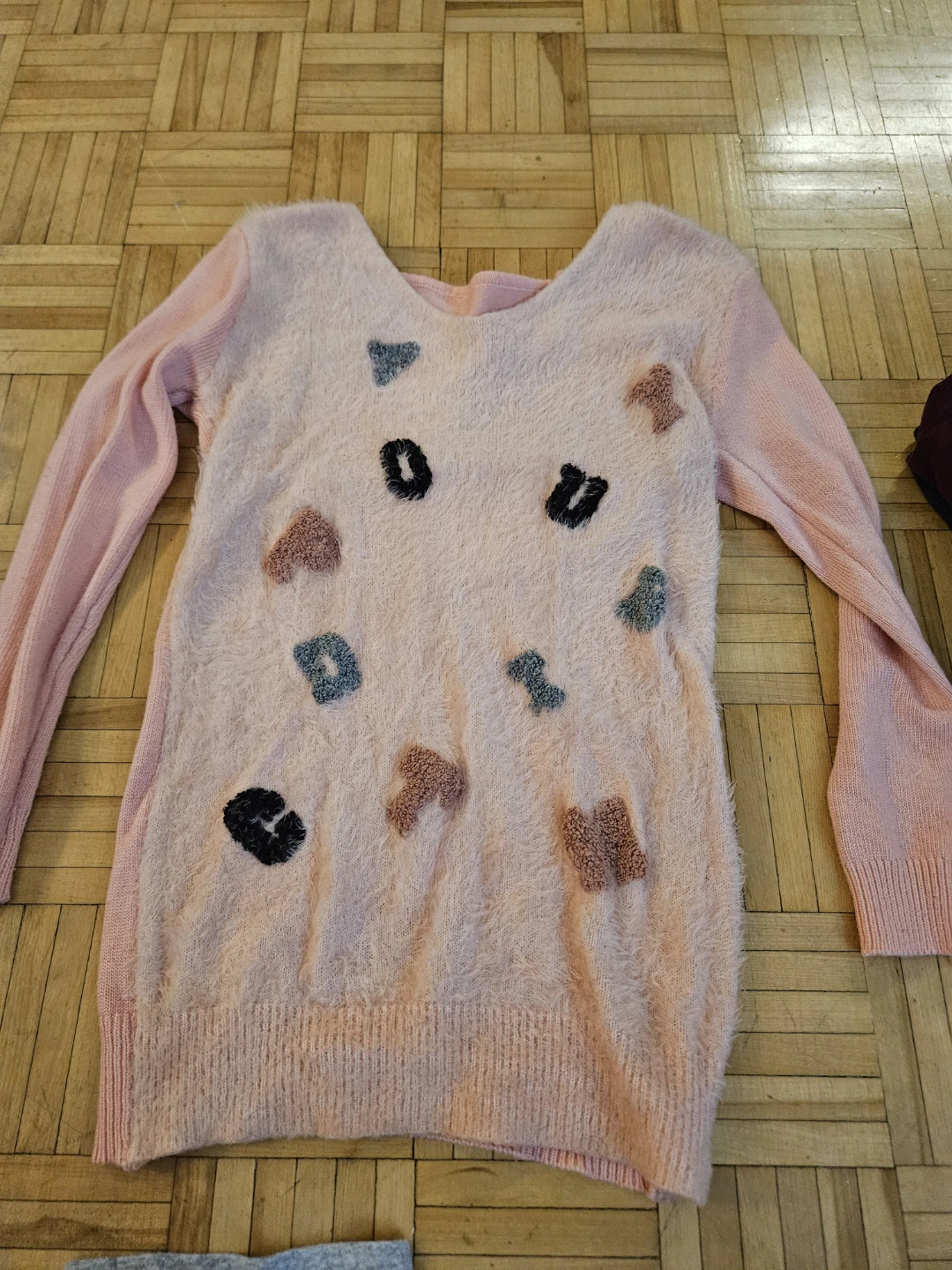 Pink fuzzy sweater with face graphic