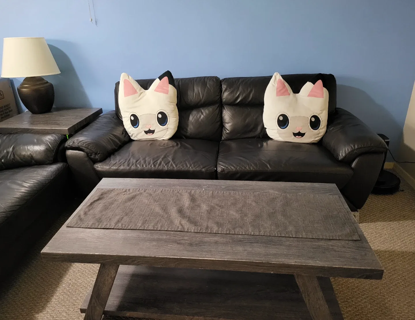 2 black sofa with tables and pillows