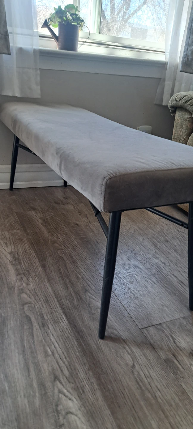 Grey upholstered bench with black metal legs