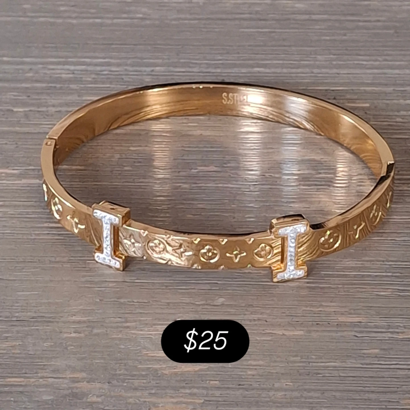 Gold tone cuff bracelet with decorative pattern and stones