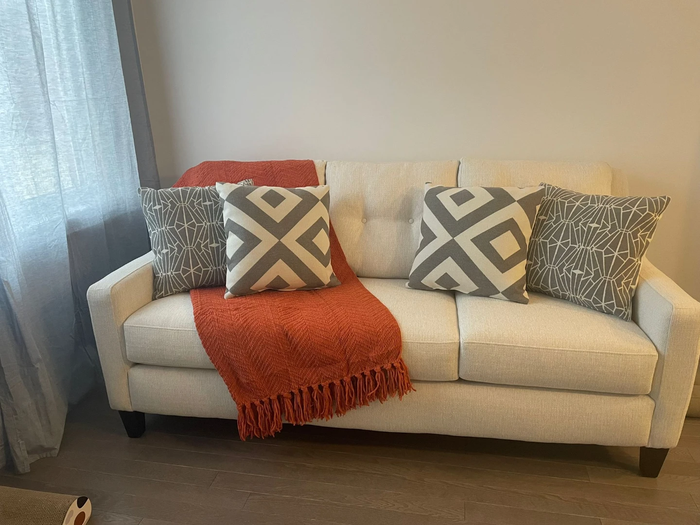 Cream Sofa with Throw Blanket and Pillows