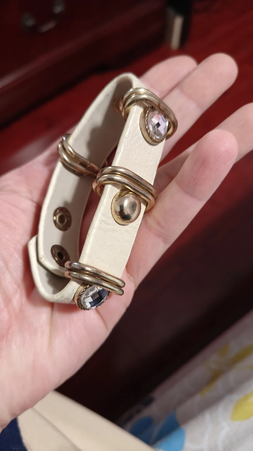White leather-look bracelet with gold accents and rhinestones