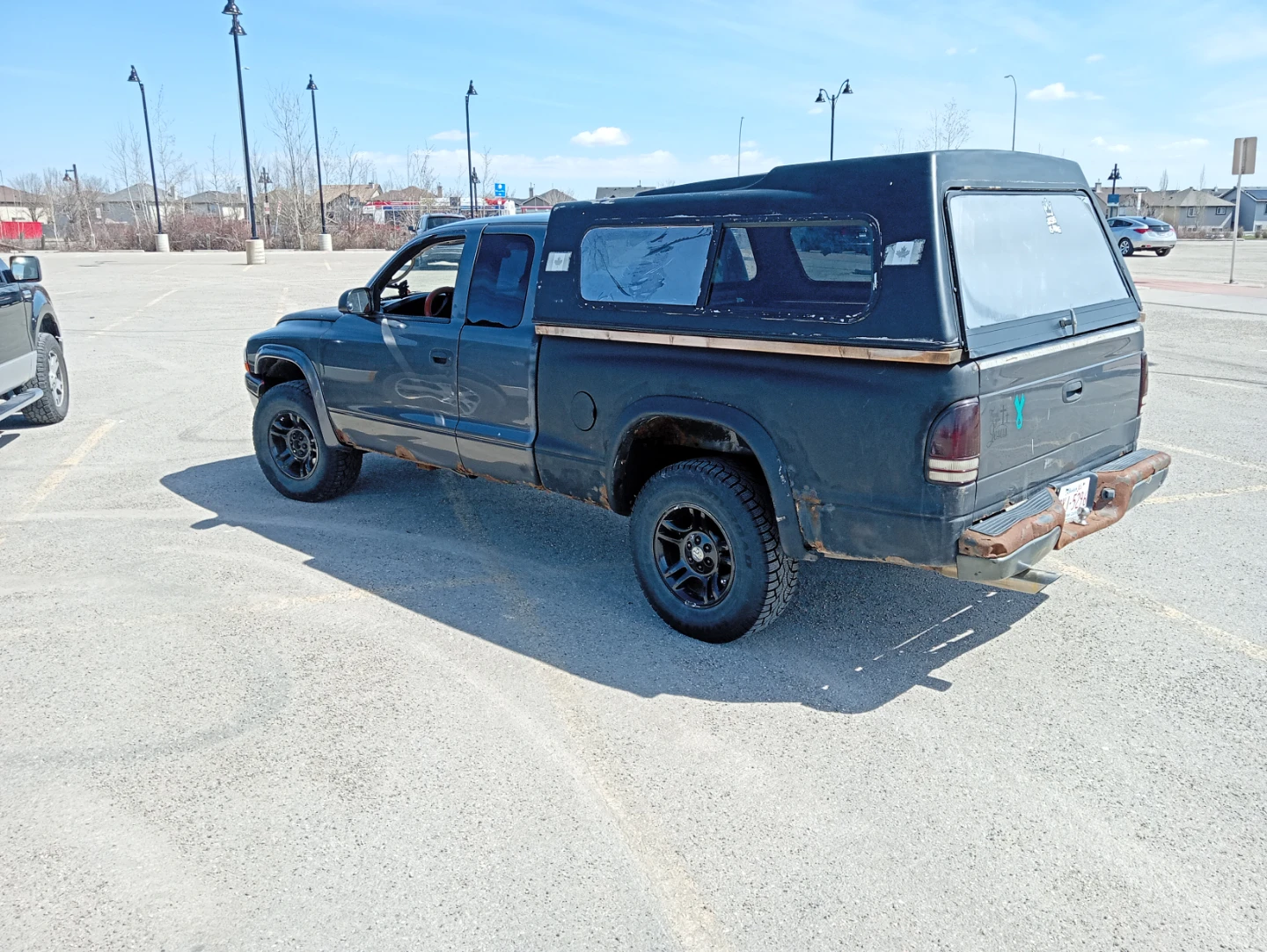 Grey Dodge Dakota Quad Cab Truck with Camper Shell