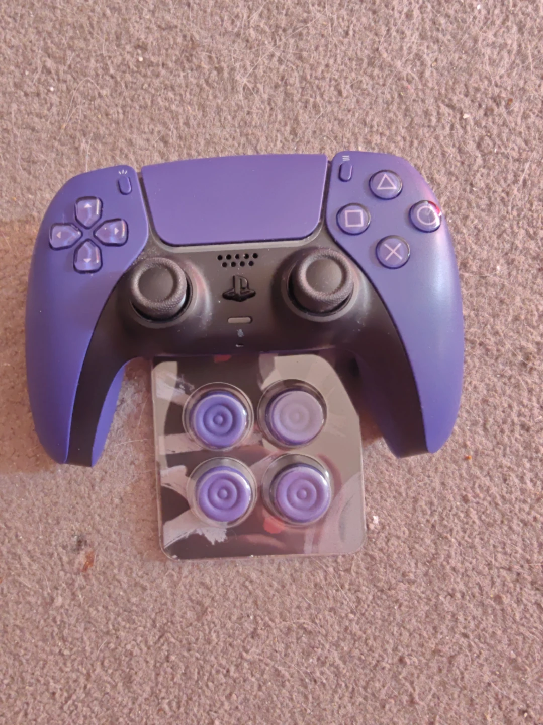 Purple PS5 controller with thumb caps and a charging stand - photo 2