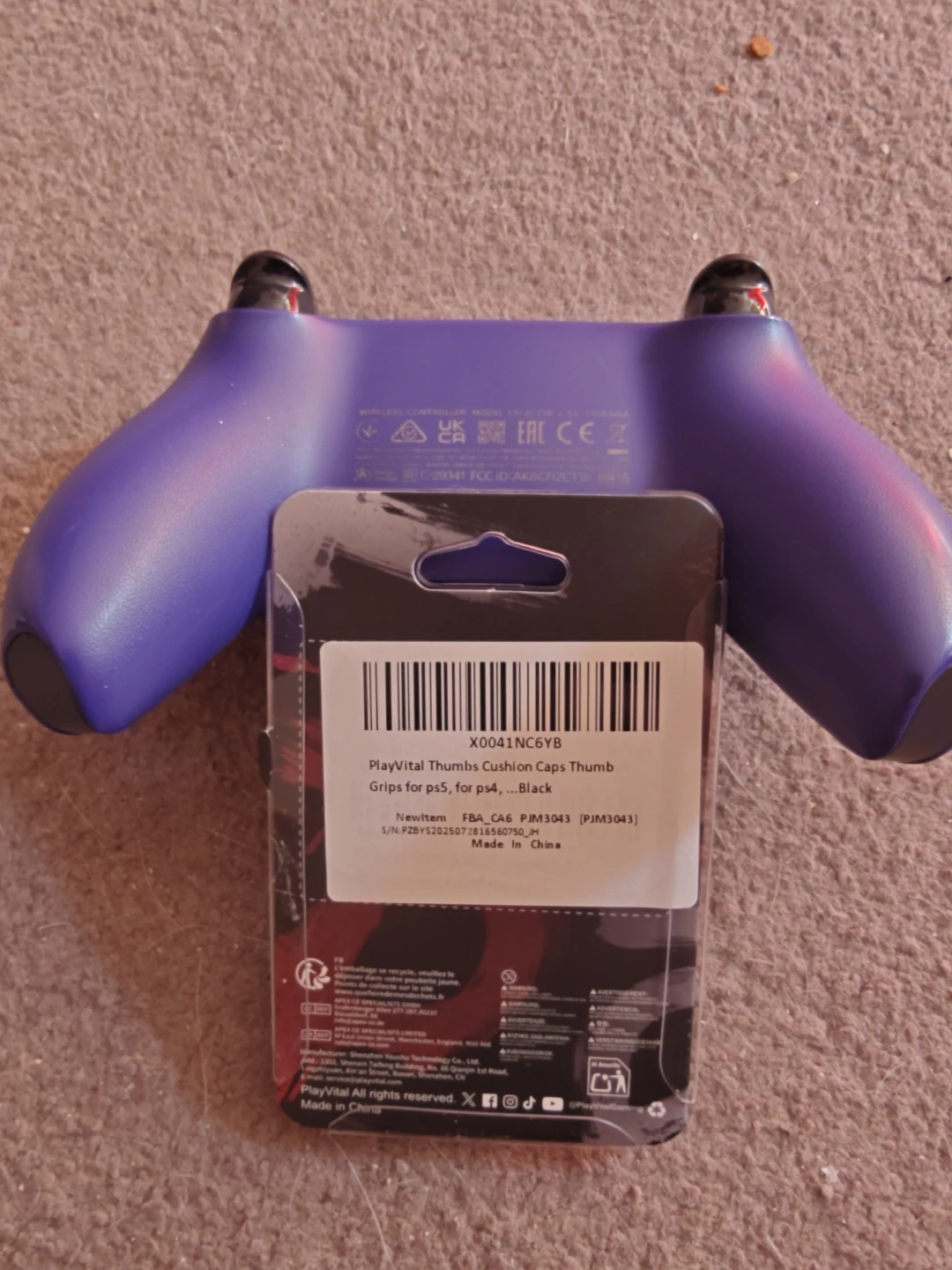 Purple PS5 controller with thumb caps and a charging stand - photo 3