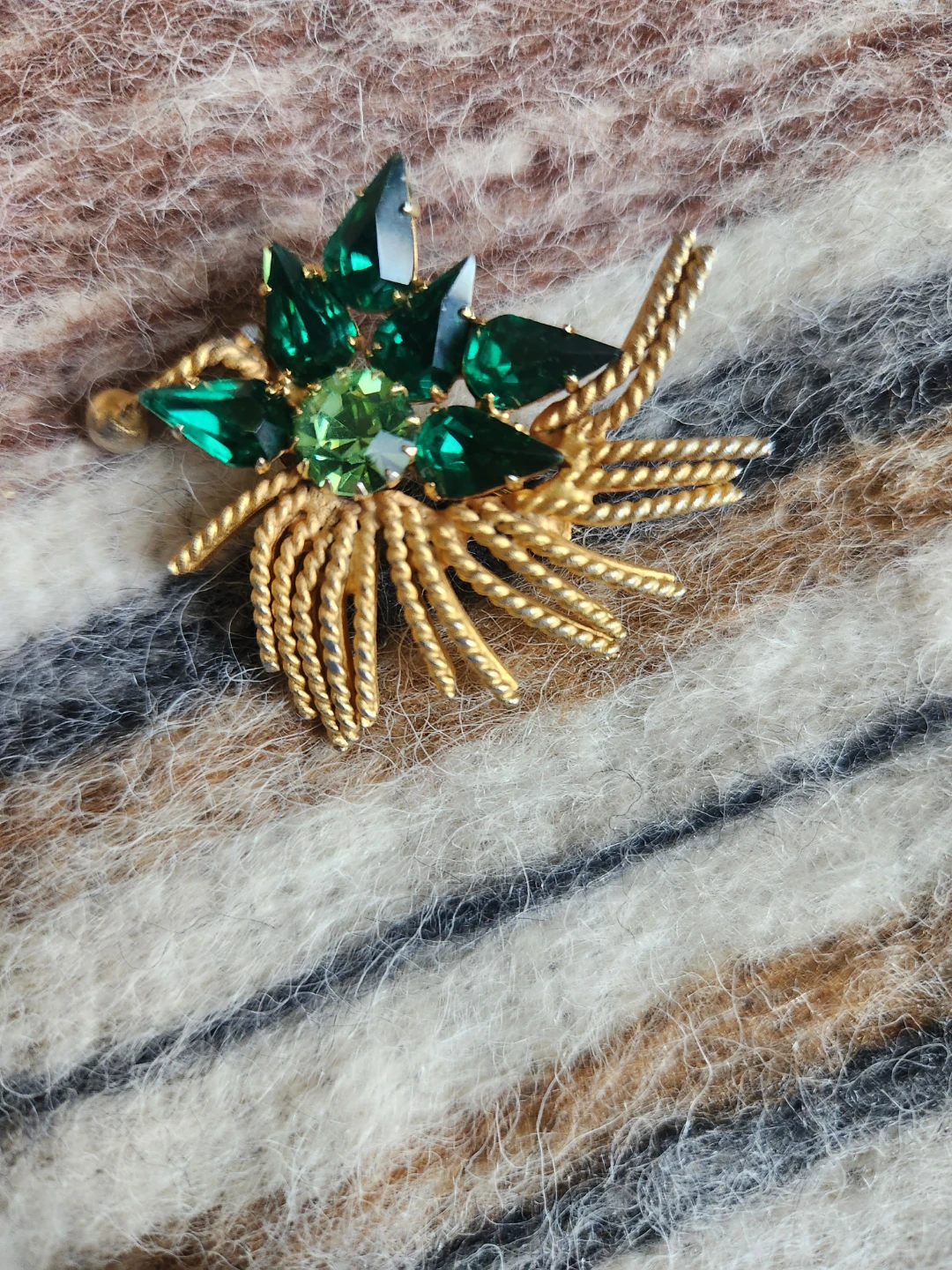 Gold tone brooch with green stones