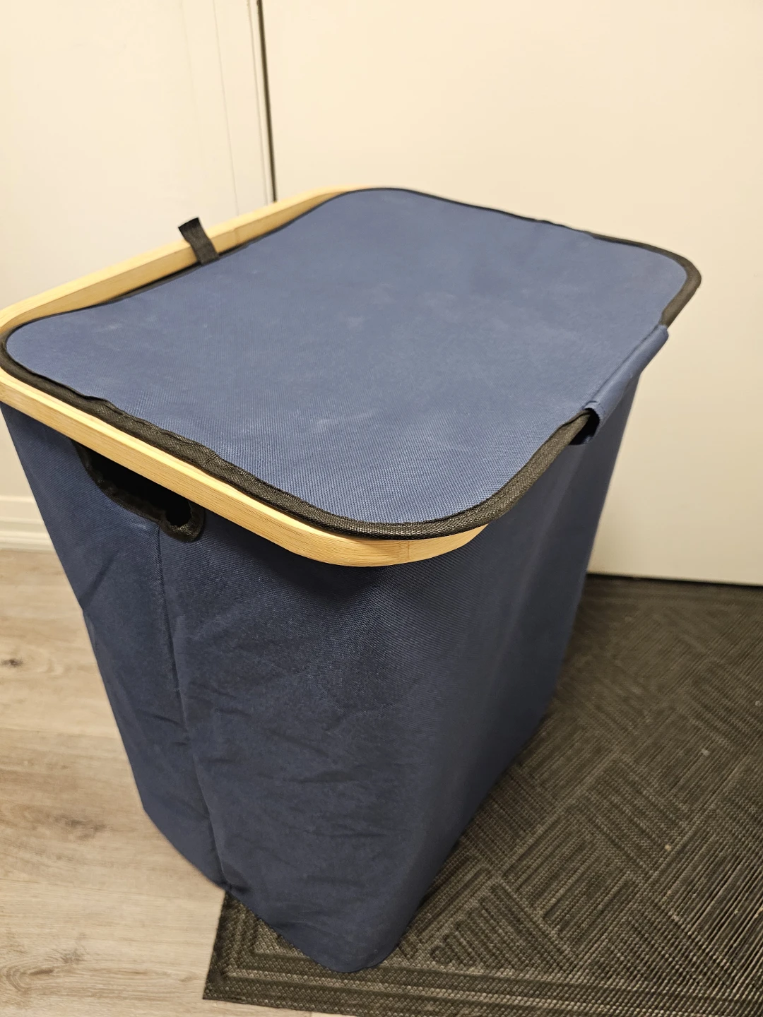 Blue fabric laundry hamper with wooden rim